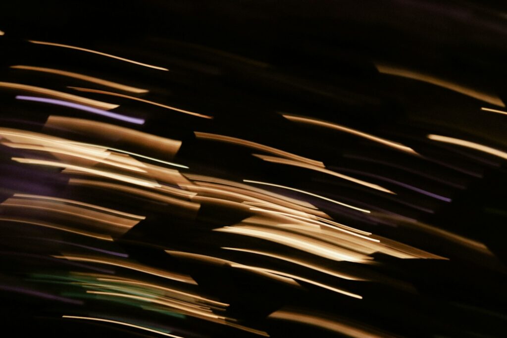 Abstract streaks of golden light against black